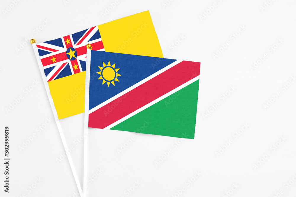 Namibia and Niue stick flags on white background. High quality fabric, miniature national flag. Peaceful global concept.White floor for copy space. Namibia and Niue stick flags on white background. High quality fabric, miniature national flag. Peaceful global concept.White floor for copy space.