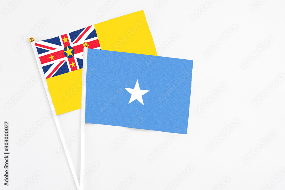 Somalia and Niue stick flags on white background. High quality fabric, miniature national flag. Peaceful global concept.White floor for copy space. Somalia and Niue stick flags on white background. High quality fabric, miniature national flag. Peaceful global concept.White floor for copy space.