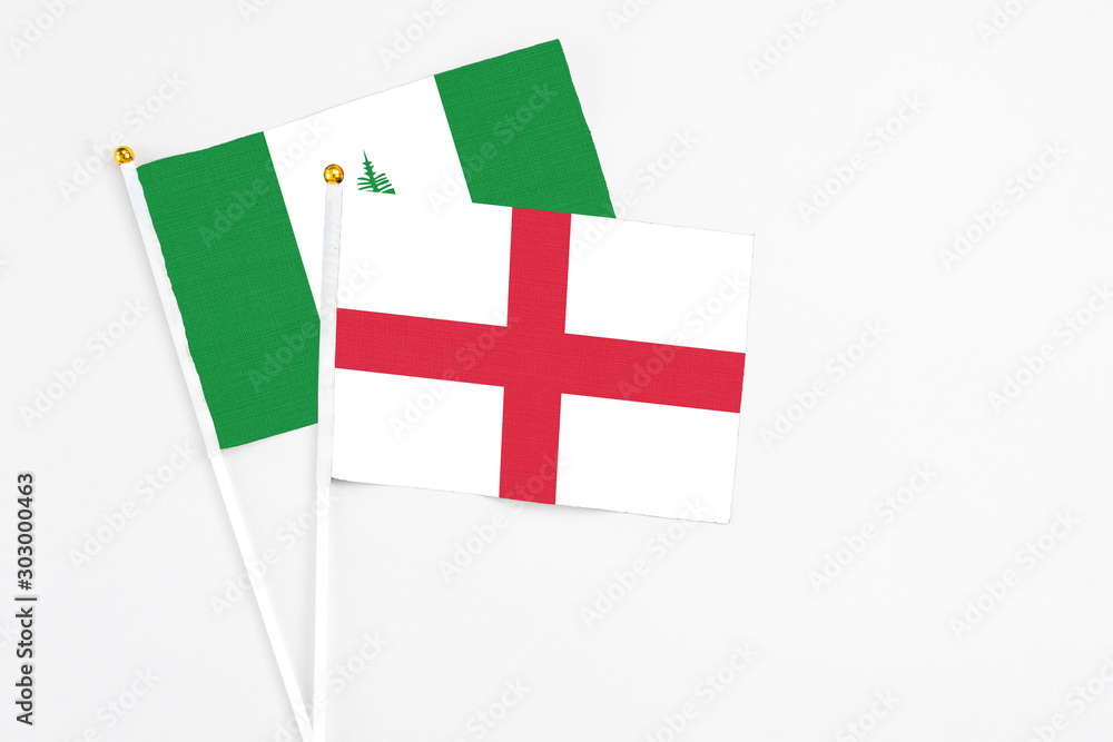England and Norfolk Island stick flags on white background. High quality fabric, miniature national flag. Peaceful global concept.White floor for copy space.