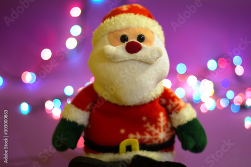 A Santa Claus puppet is sitting, with a beautiful bokeh that is visible in the background