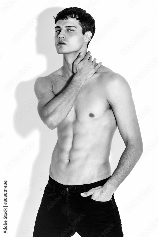 Fototapeta premium Black and White Muscle strong beautiful stripped male model in denim jeans on white isolated font background with shadow