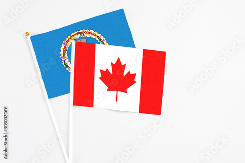 Canada and Northern Mariana Islands stick flags on white background. High quality fabric, miniature national flag. Peaceful global concept.White floor for copy space.