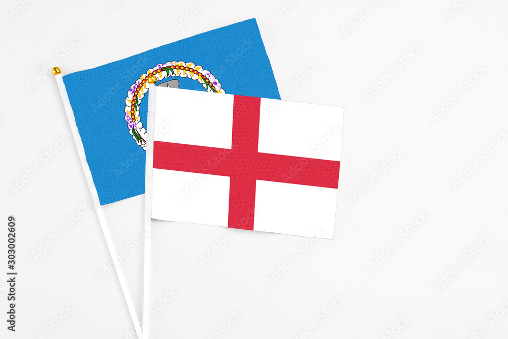 England and Northern Mariana Islands stick flags on white background. High quality fabric, miniature national flag. Peaceful global concept.White floor for copy space.