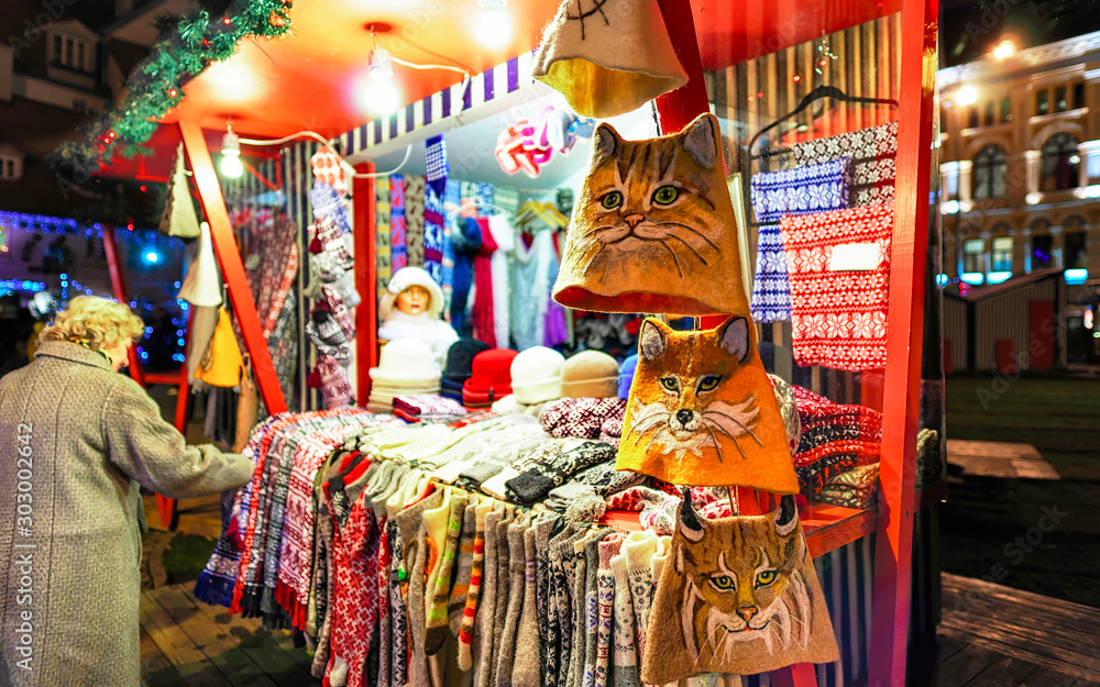 Wool mittens, gloves, socks and hats on stalls at Christmas market at Riga of Latvia winter. Street Xmas and holiday fair in European city or town. Advent Decoration with Crafts Items on Bazaar