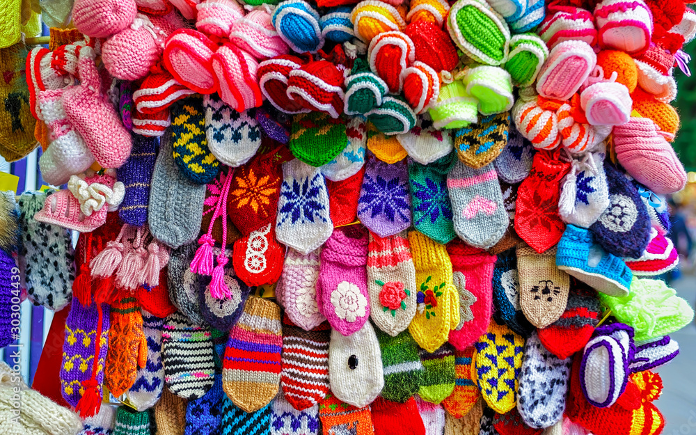 Colorful handmade socks and mittens on stalls of Christmas market in Riga of Latvia winter. Street Xmas and holiday fair in European city or town. Advent Decoration with Crafts Items on Bazaar