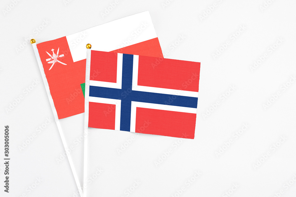 Norway and Oman stick flags on white background. High quality fabric, miniature national flag. Peaceful global concept.White floor for copy space.