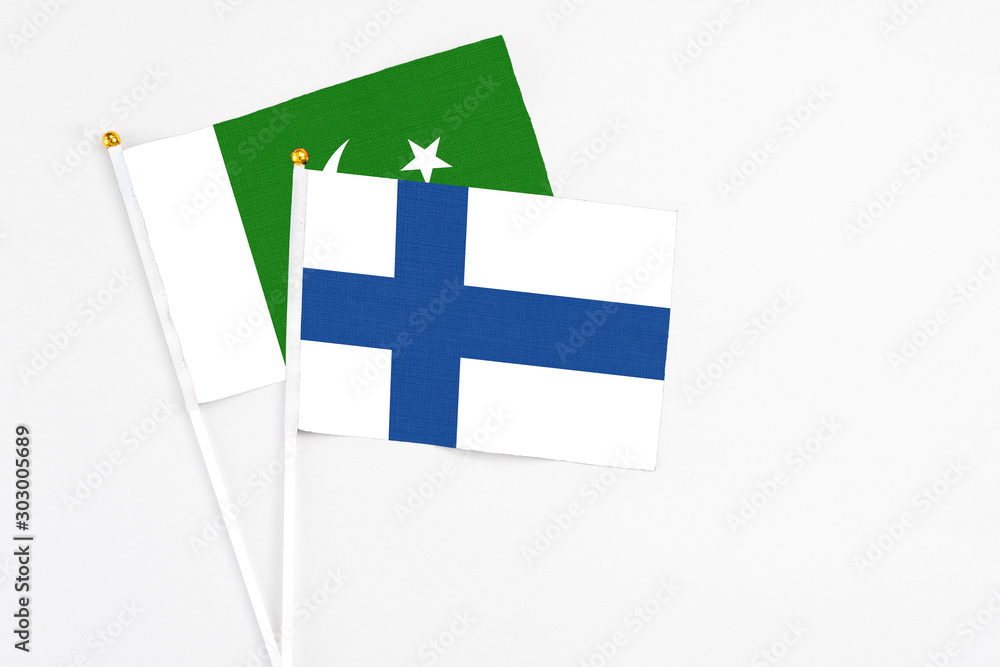 Finland and Pakistan stick flags on white background. High quality fabric, miniature national flag. Peaceful global concept.White floor for copy space.