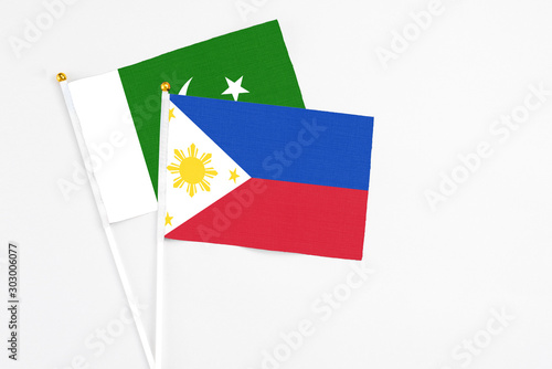 Philippines and Pakistan stick flags on white background. High quality fabric  miniature national flag. Peaceful global concept.White floor for copy space.