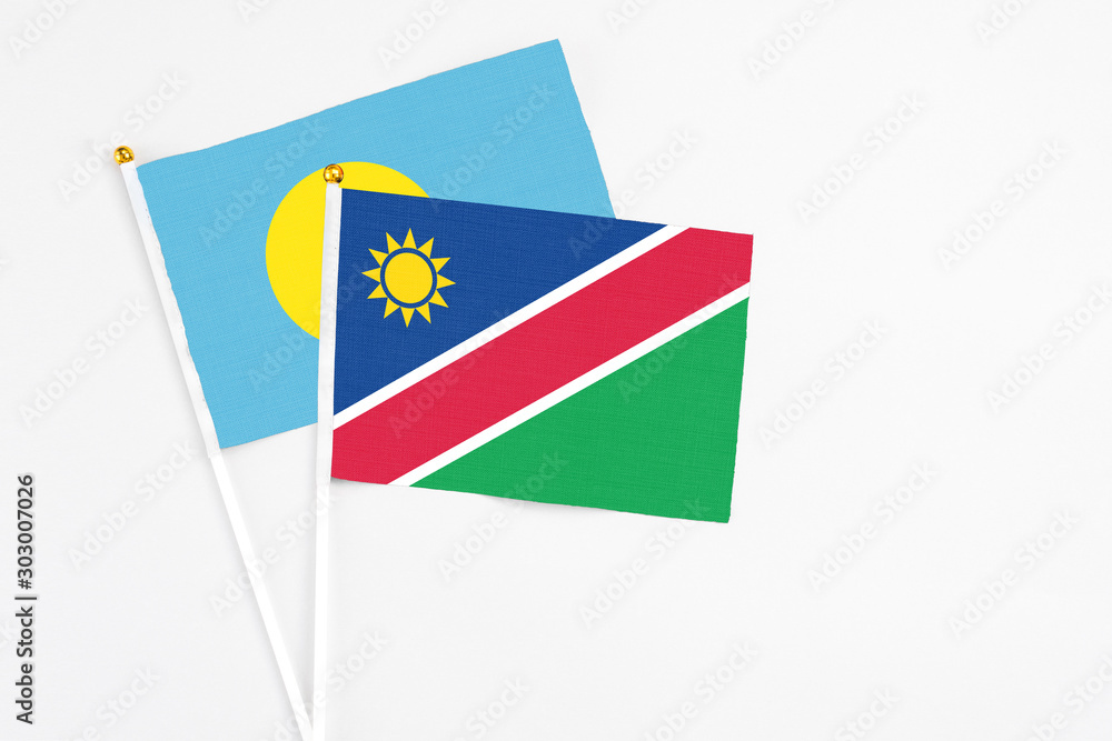 Namibia and Palau stick flags on white background. High quality fabric, miniature national flag. Peaceful global concept.White floor for copy space. Namibia and Palau stick flags on white background. High quality fabric, miniature national flag. Peaceful global concept.White floor for copy space.