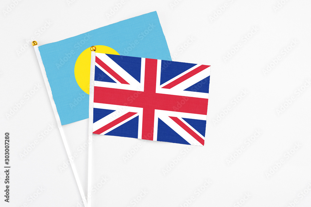 United Kingdom and Palau stick flags on white background. High quality fabric, miniature national flag. Peaceful global concept.White floor for copy space. United Kingdom and Palau stick flags on white background. High quality fabric, miniature national flag. Peaceful global concept.White floor for copy space.