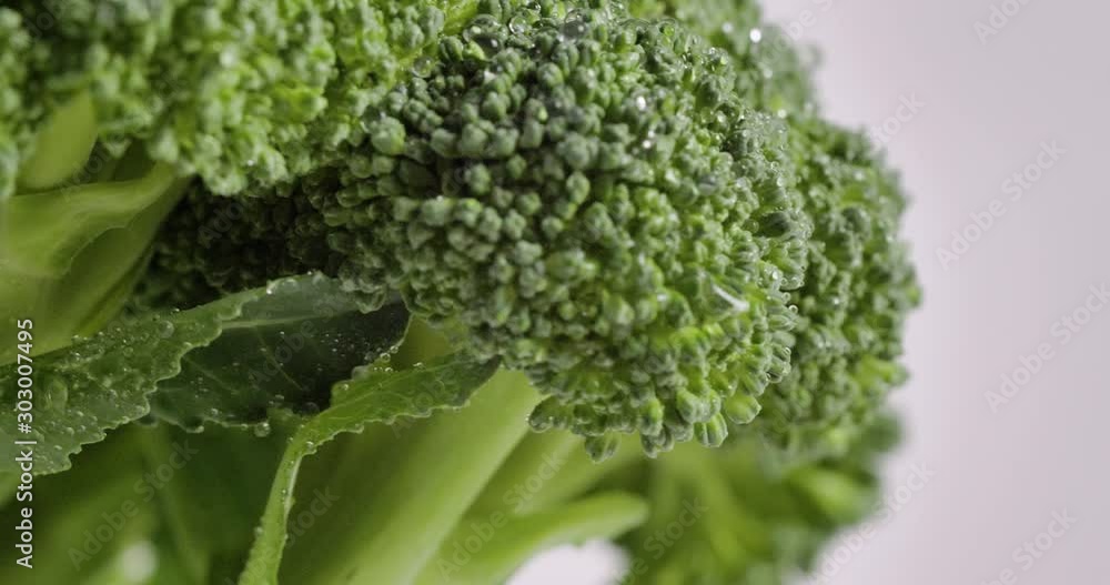 Green fresh broccoli vegetables rotating on white isolated background. Vitamin health care food. 4k Close up. Green fresh broccoli vegetables rotating on white isolated background. Vitamin health care food. 4k Close up.