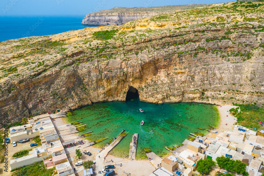 The Inland Sea and tourist boat. Dwejra is a lagoon of seawater on the island of Gozo. Aerial view of Sea Tunnel near Azure window. Mediterranean sea. Malta island