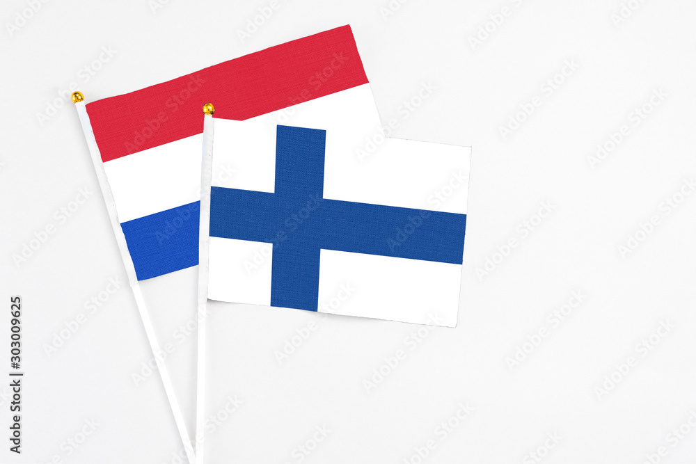 Finland and Paraguay stick flags on white background. High quality fabric, miniature national flag. Peaceful global concept.White floor for copy space.
