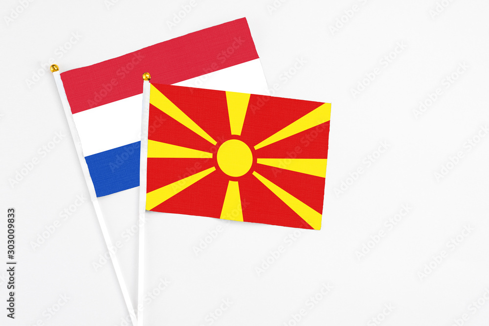 Macedonia and Paraguay stick flags on white background. High quality fabric, miniature national flag. Peaceful global concept.White floor for copy space.