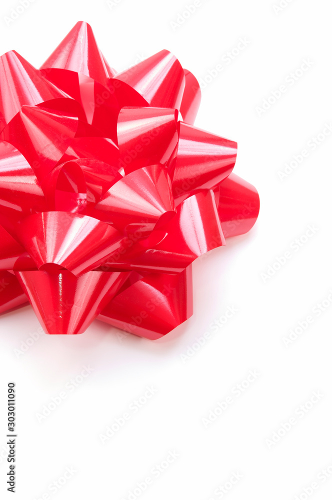 Voluminous gift bow in bright shiny red on white background Voluminous gift bow in bright shiny red on white background