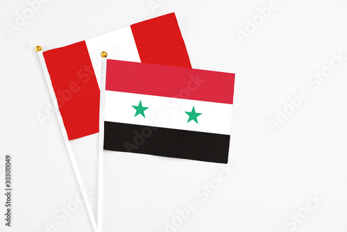 Syria and Peru stick flags on white background. High quality fabric, miniature national flag. Peaceful global concept.White floor for copy space.