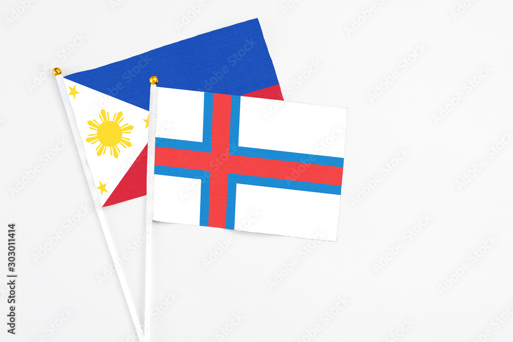 Faroe Islands and Philippines stick flags on white background. High quality fabric, miniature national flag. Peaceful global concept.White floor for copy space.