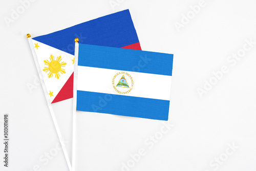 Free Download Nicaragua and Philippines stick flags on white background. High quality fabric, miniature national flag. Peaceful global concept.White floor for copy space. - GFXLoad