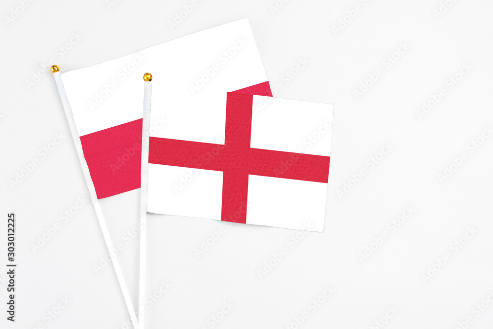 England and Poland stick flags on white background. High quality fabric, miniature national flag. Peaceful global concept.White floor for copy space.