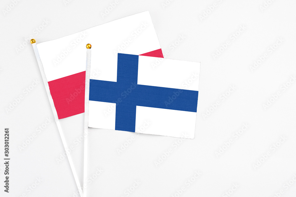 Finland and Poland stick flags on white background. High quality fabric, miniature national flag. Peaceful global concept.White floor for copy space.