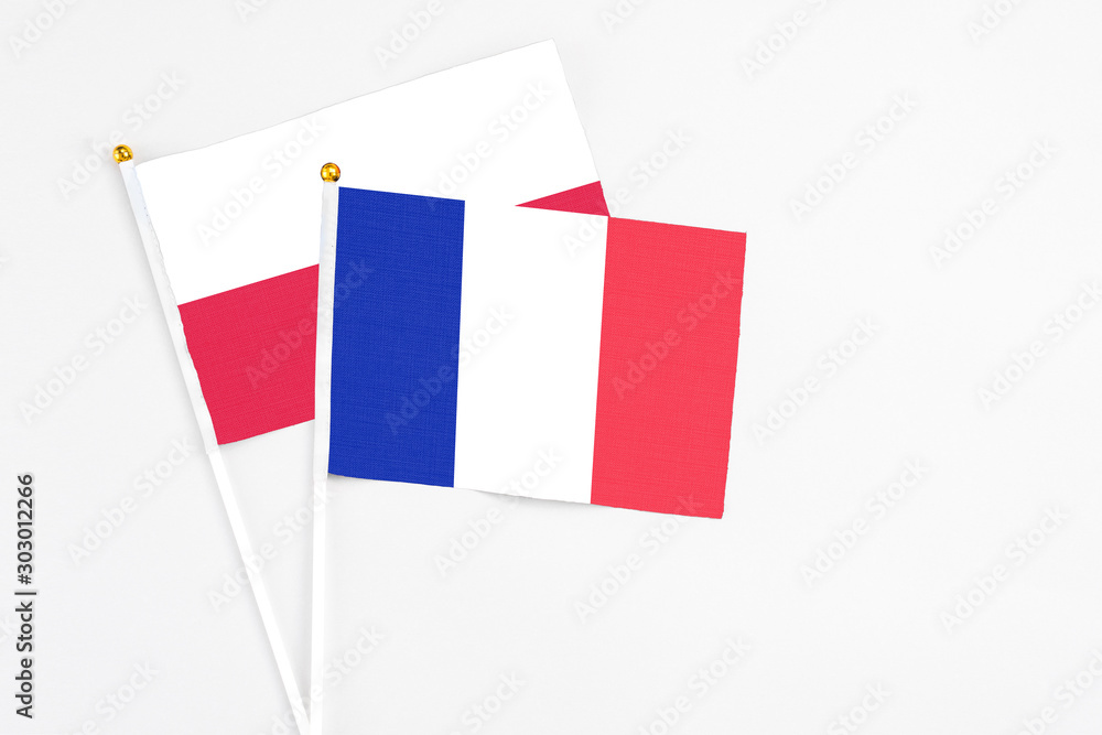France and Poland stick flags on white background. High quality fabric, miniature national flag. Peaceful global concept.White floor for copy space. France and Poland stick flags on white background. High quality fabric, miniature national flag. Peaceful global concept.White floor for copy space.