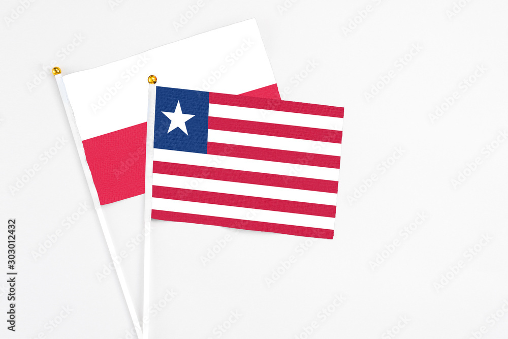 Liberia and Poland stick flags on white background. High quality fabric, miniature national flag. Peaceful global concept.White floor for copy space. Liberia and Poland stick flags on white background. High quality fabric, miniature national flag. Peaceful global concept.White floor for copy space.