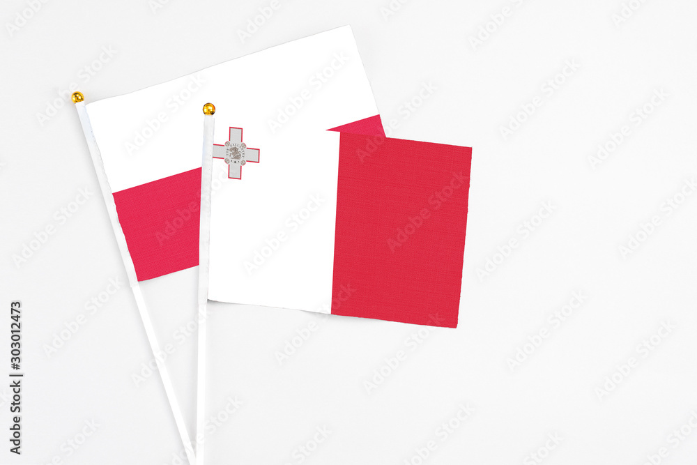 Malta and Poland stick flags on white background. High quality fabric, miniature national flag. Peaceful global concept.White floor for copy space. Malta and Poland stick flags on white background. High quality fabric, miniature national flag. Peaceful global concept.White floor for copy space.