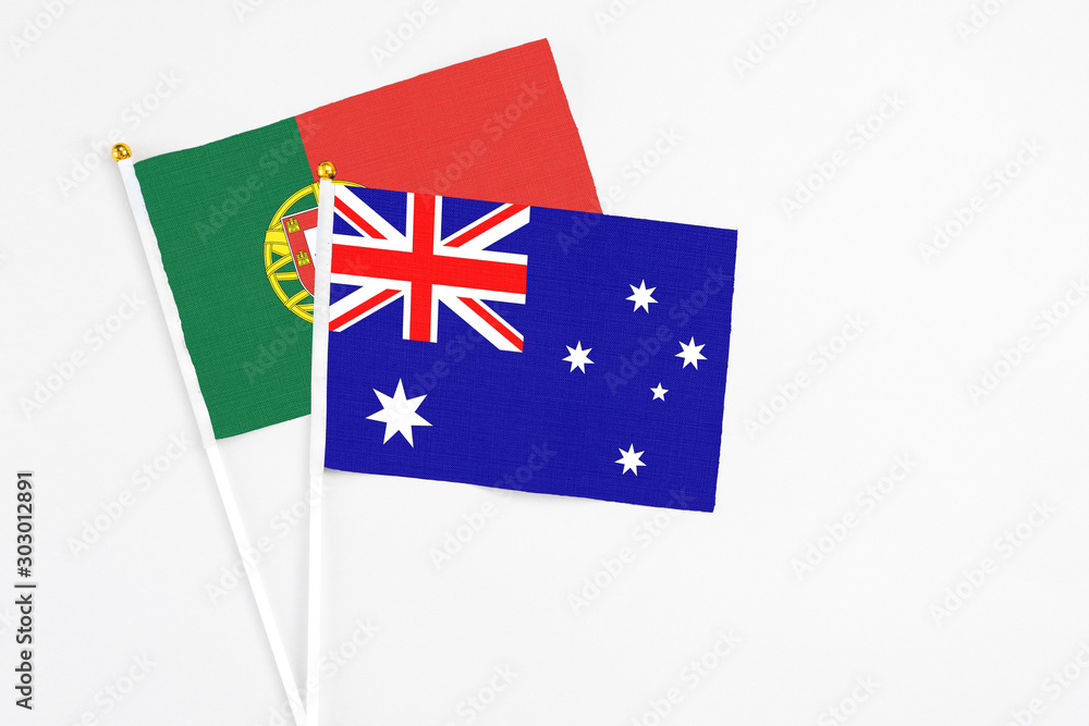 Fototapeta premium Australia and Portugal stick flags on white background. High quality fabric, miniature national flag. Peaceful global concept.White floor for copy space.