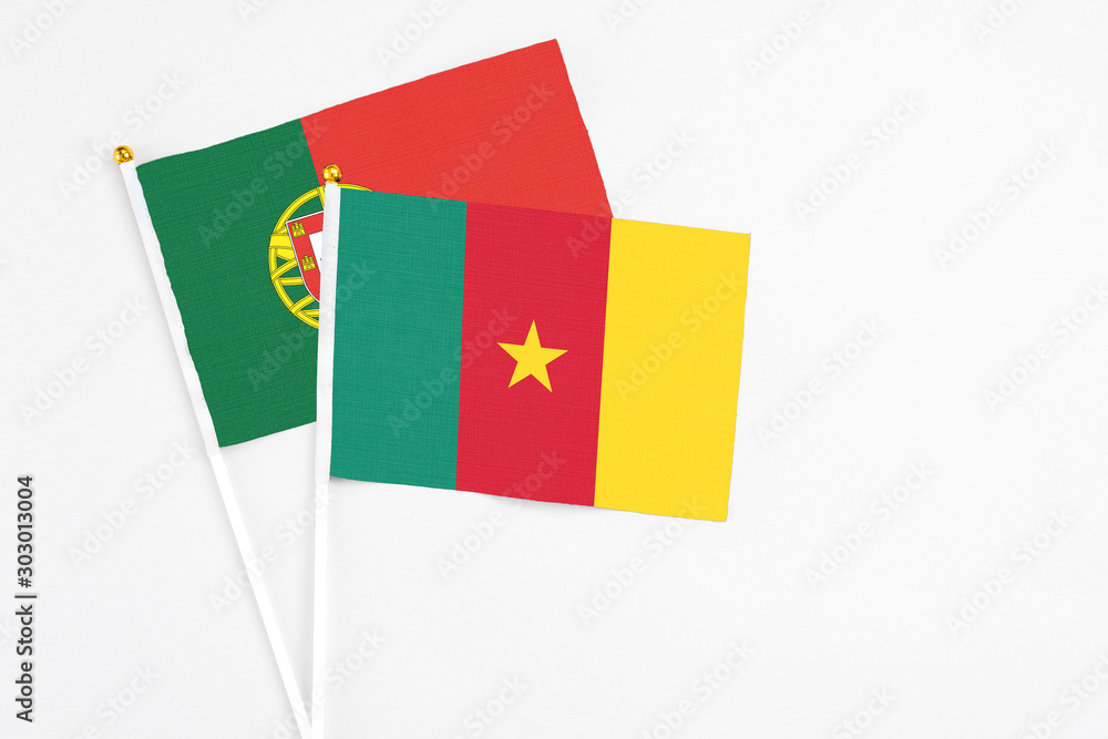Cameroon and Portugal stick flags on white background. High quality fabric, miniature national flag. Peaceful global concept.White floor for copy space.