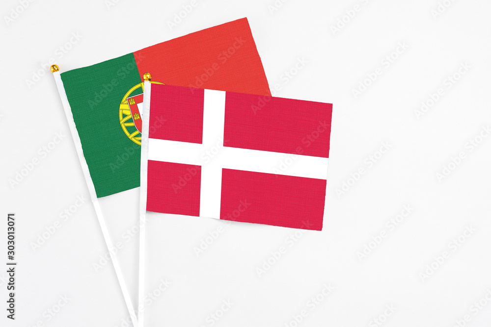 Denmark and Portugal stick flags on white background. High quality fabric, miniature national flag. Peaceful global concept.White floor for copy space.