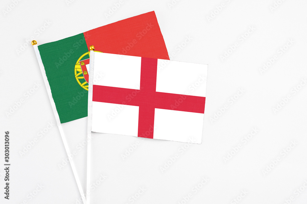 England and Portugal stick flags on white background. High quality fabric, miniature national flag. Peaceful global concept.White floor for copy space.