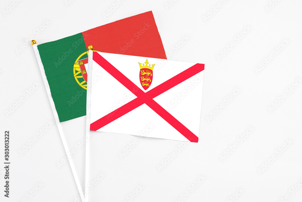 Jersey and Portugal stick flags on white background. High quality fabric, miniature national flag. Peaceful global concept.White floor for copy space. Jersey and Portugal stick flags on white background. High quality fabric, miniature national flag. Peaceful global concept.White floor for copy space.