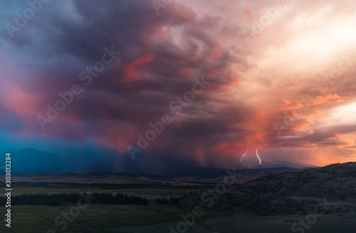 thunderstorm in the landscape with the hils and the forest and the mountains and the lighting bolt