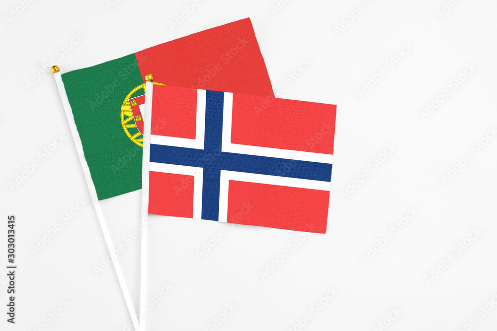 Norway and Portugal stick flags on white background. High quality fabric, miniature national flag. Peaceful global concept.White floor for copy space.
