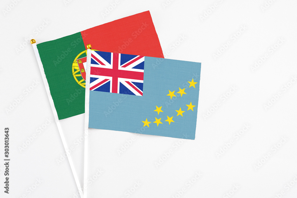 Fototapeta premium Tuvalu and Portugal stick flags on white background. High quality fabric, miniature national flag. Peaceful global concept.White floor for copy space.