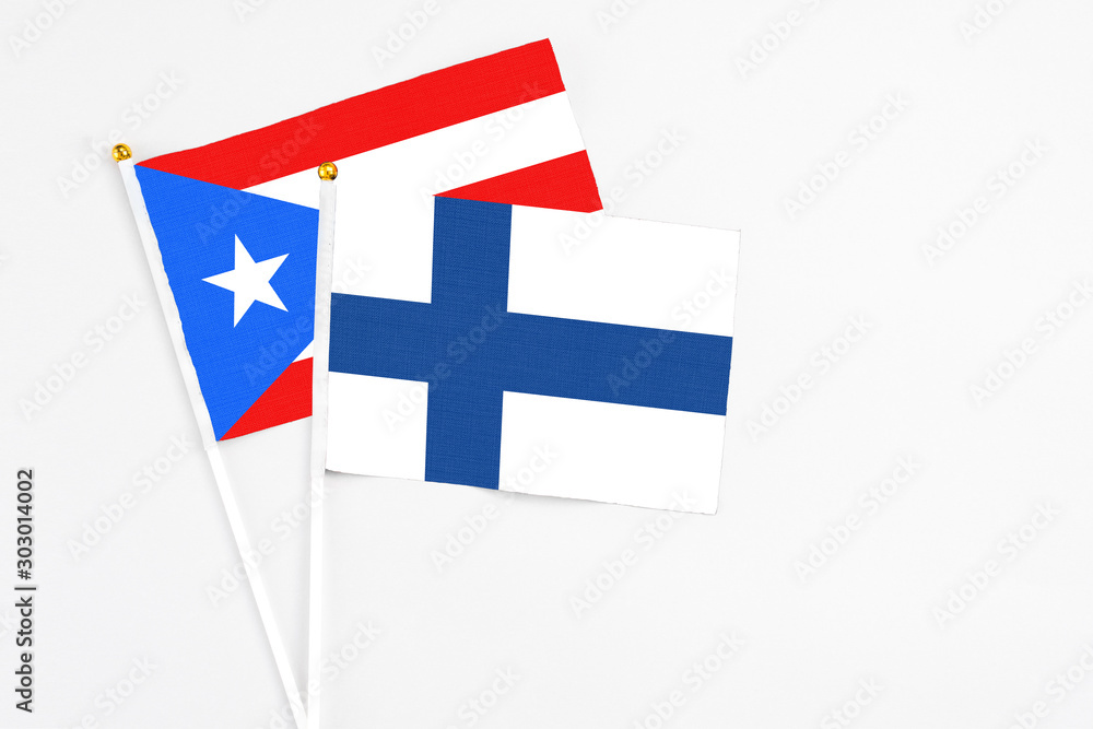 Finland and Puerto Rico stick flags on white background. High quality fabric, miniature national flag. Peaceful global concept.White floor for copy space.
