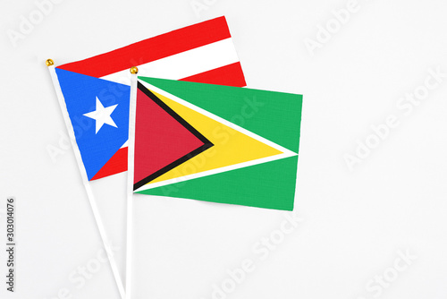 Free Download Guyana and Puerto Rico stick flags on white background. High quality fabric, miniature national flag. Peaceful global concept.White floor for copy space. - GFXLoad
