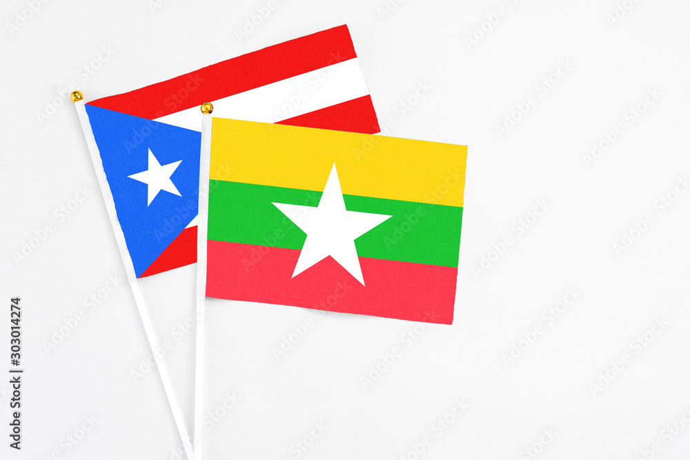 Fototapeta premium Myanmar and Puerto Rico stick flags on white background. High quality fabric, miniature national flag. Peaceful global concept.White floor for copy space.