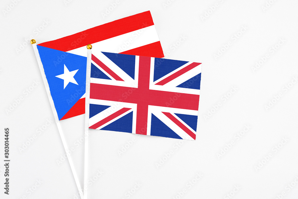 Fototapeta premium United Kingdom and Puerto Rico stick flags on white background. High quality fabric, miniature national flag. Peaceful global concept.White floor for copy space.