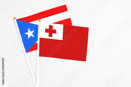 Tonga and Puerto Rico stick flags on white background. High quality fabric, miniature national flag. Peaceful global concept.White floor for copy space. photo