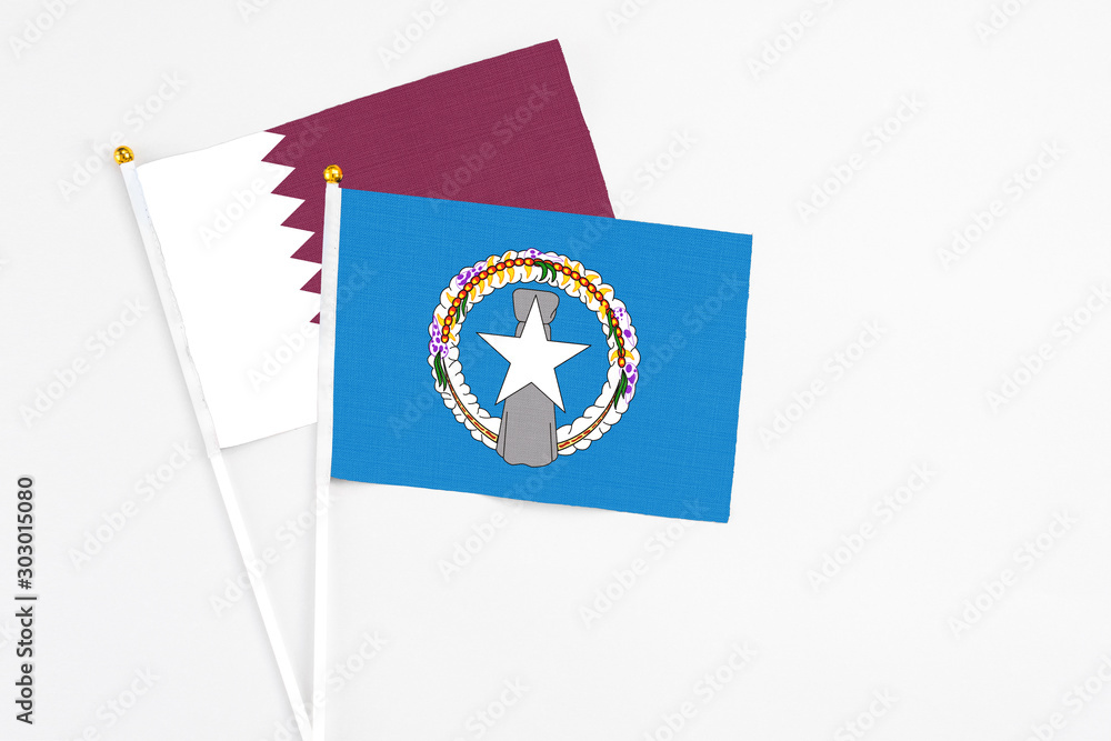 Northern Mariana Islands and Qatar stick flags on white background. High quality fabric, miniature national flag. Peaceful global concept.White floor for copy space. Northern Mariana Islands and Qatar stick flags on white background. High quality fabric, miniature national flag. Peaceful global concept.White floor for copy space.
