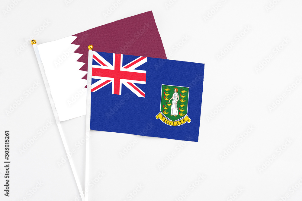 Fototapeta premium British Virgin Islands and Qatar stick flags on white background. High quality fabric, miniature national flag. Peaceful global concept.White floor for copy space.