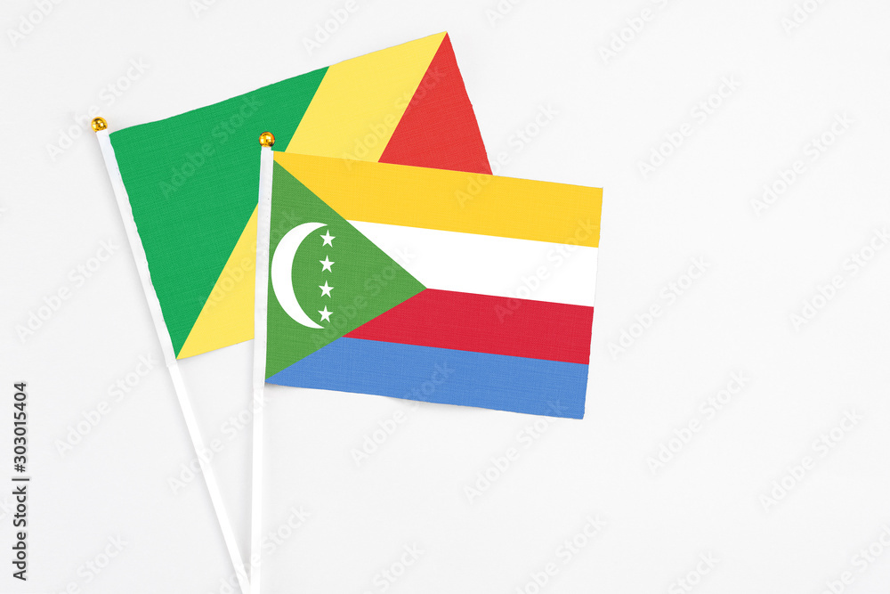 Comoros and Republic Of The Congo stick flags on white background. High quality fabric, miniature national flag. Peaceful global concept.White floor for copy space. Comoros and Republic Of The Congo stick flags on white background. High quality fabric, miniature national flag. Peaceful global concept.White floor for copy space.