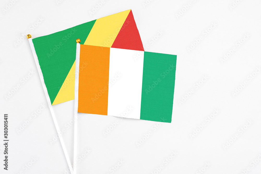 Cote D'Ivoire and Republic Of The Congo stick flags on white background. High quality fabric, miniature national flag. Peaceful global concept.White floor for copy space. Cote D'Ivoire and Republic Of The Congo stick flags on white background. High quality fabric, miniature national flag. Peaceful global concept.White floor for copy space.