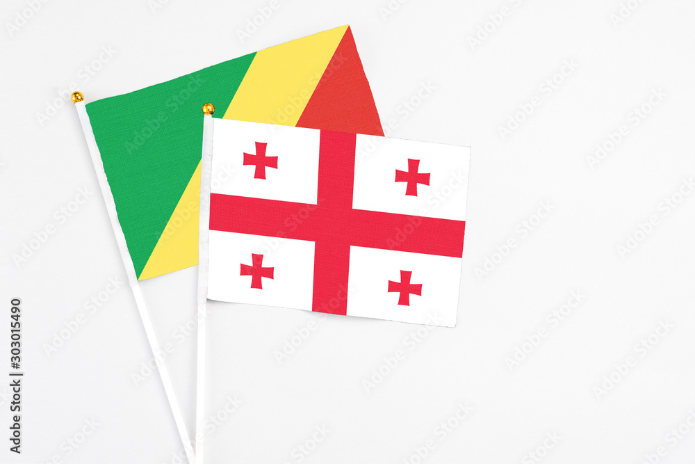Georgia and Republic Of The Congo stick flags on white background. High quality fabric, miniature national flag. Peaceful global concept.White floor for copy space.