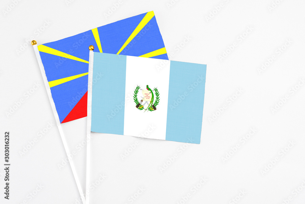 Guatemala and Reunion stick flags on white background. High quality fabric, miniature national flag. Peaceful global concept.White floor for copy space. Guatemala and Reunion stick flags on white background. High quality fabric, miniature national flag. Peaceful global concept.White floor for copy space.