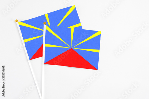 Reunion and Reunion stick flags on white background. High quality fabric, miniature national flag. Peaceful global concept.White floor for copy space.