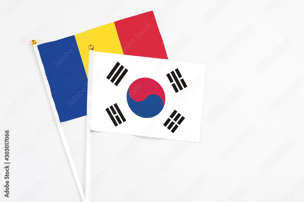 South Korea and Romania stick flags on white background. High quality fabric, miniature national flag. Peaceful global concept.White floor for copy space.