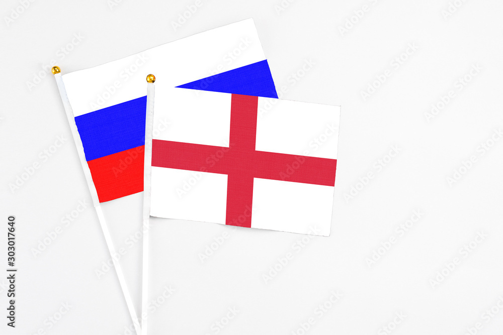 England and Russia stick flags on white background. High quality fabric, miniature national flag. Peaceful global concept.White floor for copy space.