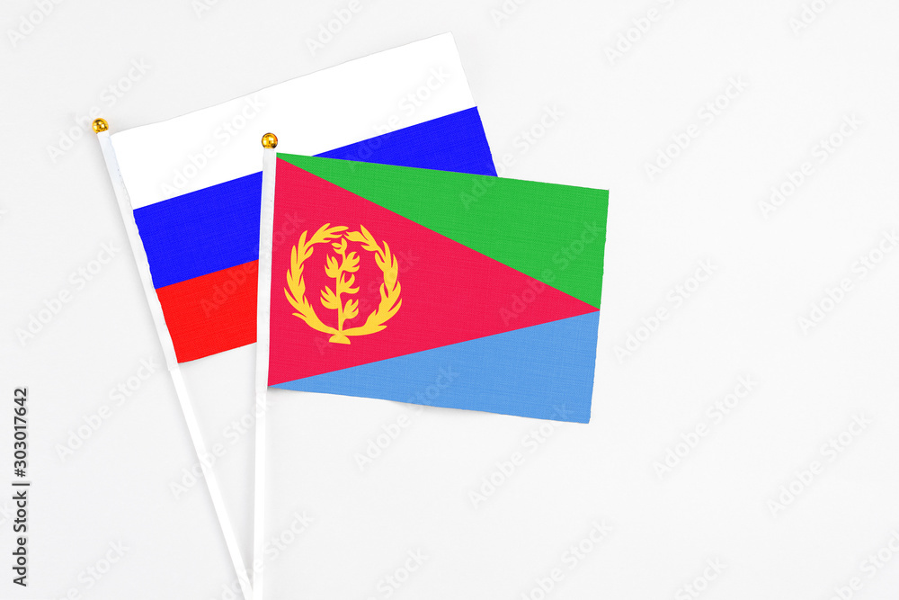 Eritrea and Russia stick flags on white background. High quality fabric, miniature national flag. Peaceful global concept.White floor for copy space. Eritrea and Russia stick flags on white background. High quality fabric, miniature national flag. Peaceful global concept.White floor for copy space.
